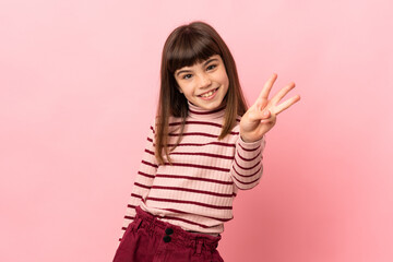 Little girl isolated on pink background happy and counting three with fingers