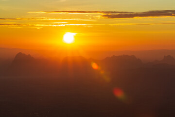 Glowing sunrise shines over mountain range.