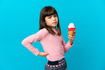 Little girl with a cornet ice cream isolated on blue background suffering from backache for having...
