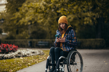Woman with disability using a smartphone while out in the city park