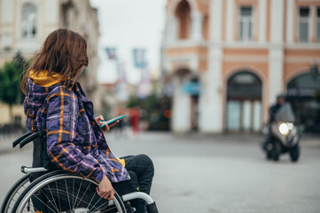 Obraz premium Woman with disability using a smartphone while out in the city