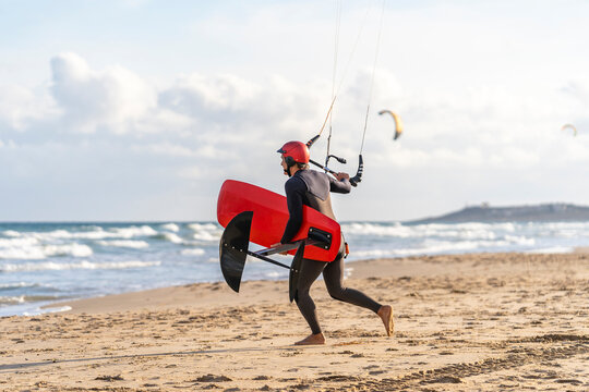 Kite surfer preparing to start sailing at sunset in the sea