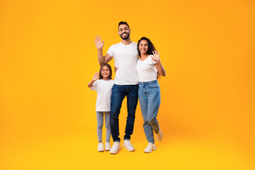 Middle-Eastern Family Waving Hands Smiling To Camera On Yellow Background