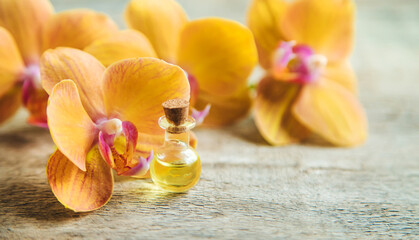 Orchid essential oil in a small bottle. Selective focus.