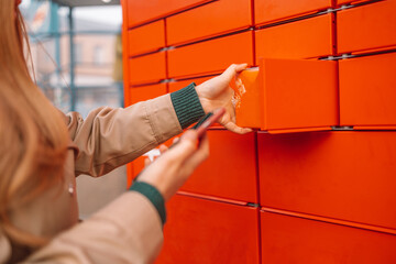 Woman client using automated self service post terminal machine or locker