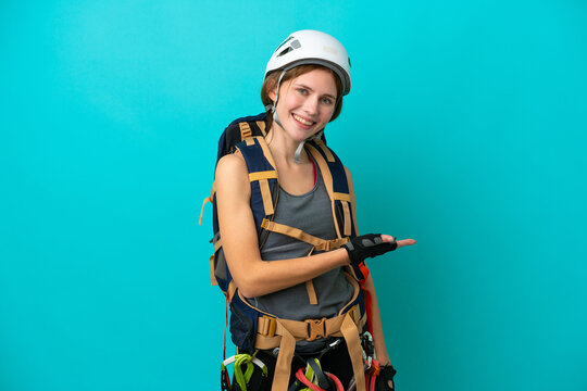 Young English Rock Climber Woman Isolated On Blue Background Presenting An Idea While Looking Smiling Towards