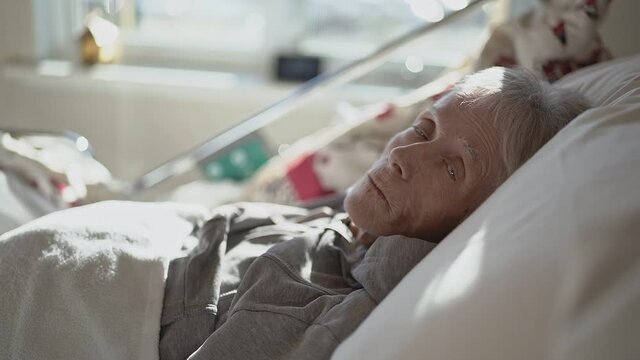 Sick, elderly senior woman in a hospital bed