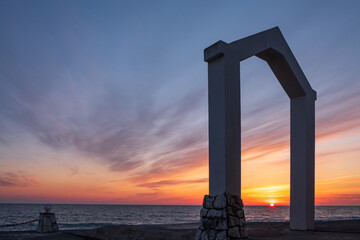 Naklejka premium the seashore during sunset, the horizon line and the triangular arch in the foreground