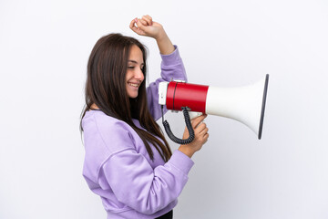 Young Ukrainian woman isolated on white background shouting through a megaphone to announce something in lateral position