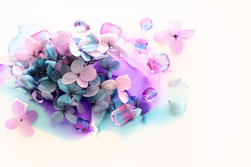 Fototapeta premium Creative image of pink and purple Hydrangea flowers on artistic ink background. Top view with copy space