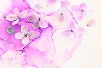 Creative image of pastel violet and pink Hydrangea flowers on artistic ink background. Top view with copy space