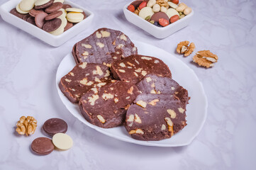 Dessert chocolate sausage with nuts on a white plate
