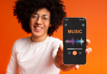 Online Audio Streaming. Black Guy Demonstrating Smartphone With Music Media Player Interface