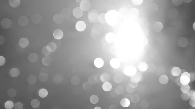Abstract sunny black and white 4k video background with sparkling shiny sun light rounded bokeh particles