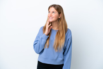 Young blonde woman isolated on white background looking up while smiling