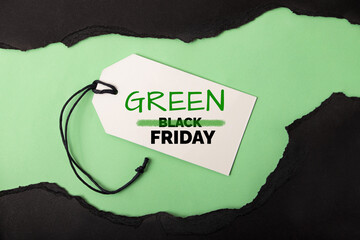 Torned paper on the green background,concept of green friday and black friday.Reducing excessive...
