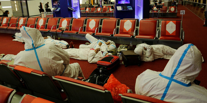 Travellers wearing full protective suits due to COVID-19 pandemic sleep in the terminal 2 of Charles de Gaulle international airport in Paris, France.