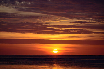 Sunset ocean beach. Bright sunrise with yellow sun under the sea surface.