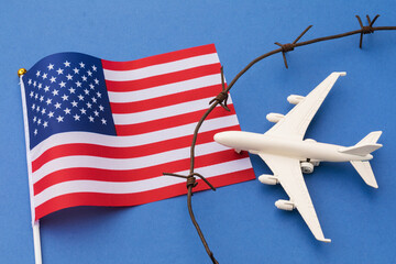 USA flag, barbed wire and toy plane on blue background, American air border violation concept