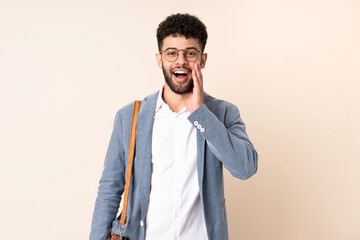 Young business Moroccan man isolated on beige background with surprise and shocked facial expression