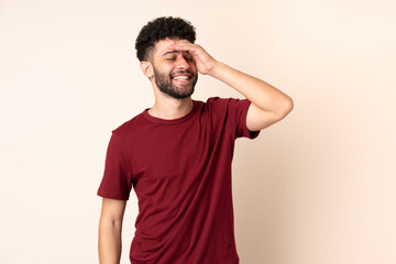 Young Moroccan man isolated on beige background smiling a lot