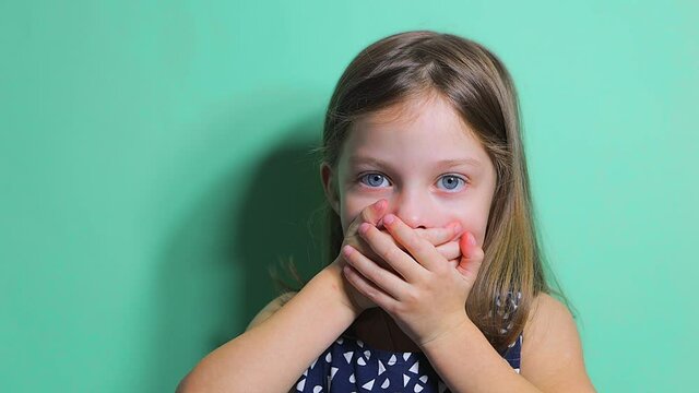 the little girl closes her mouth in fear and surprise