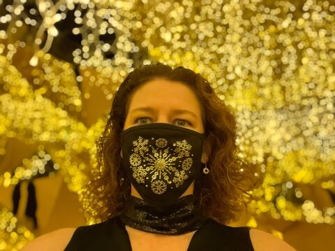 woman in a snowflake mask in  a gold room