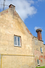 A fragment of an old German-built building with a stork nest on a chimney. Polessk, Kaliningrad region - 471509562