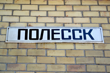 A sign-name "Polessk" on a brick wall. Kaliningrad region