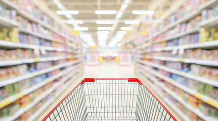 Empty red shopping cart with supermarket grocery store interior aisle abstract blurred background