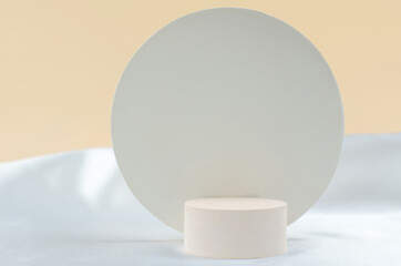Round podium for the presentation of cosmetic products. Empty beige podium on a white and beige background with geometric shapes.