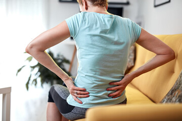 Woman with back and hip pain at home.