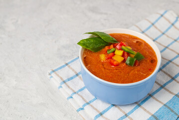 Delicious gazpacho - traditional spanish cold soup puree from vegetables in bowl on light background with copy space for text.