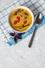 Homemade lentil soup decorated with vegetable oil, sauce and hot red pepper. Minimalistic food concept flat layout with copy space for text