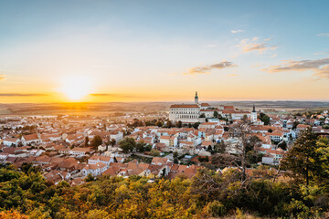 Obraz premium View of Mikulov with beautiful Baroque castle on the rock at sunset,south Moravia,Czech Republic.Dominant of town skyline.Czech Chateau in Palava wine region.Picturesque town among vineyards.