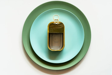 Empty opened tin can placed on plate with cutlery