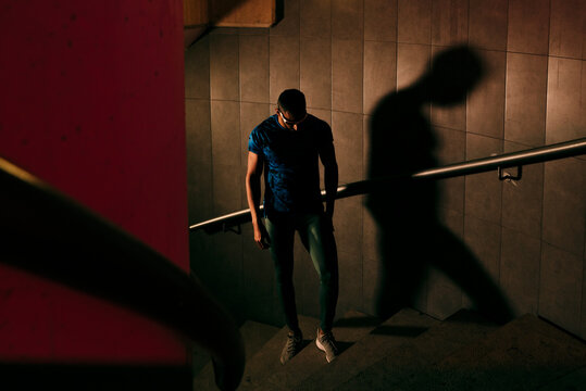 Concentrated young black athlete standing on the stairs