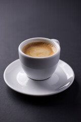 Cup of coffee on dark paper background. Close up. 