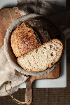 Plate with split bread loaf on chopping board