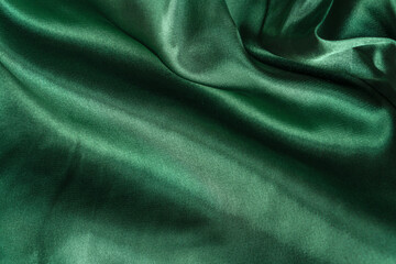 Fototapeta premium Elegant smooth green silk or satin folds closeup. Cloth texture background. Abstract wallpaper. Trendy mint green backdrop for web design. Luxury twisted fabric backplate 