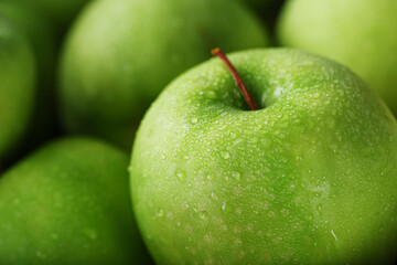 Ripe fruit of a green apple in close-up with dew drops.