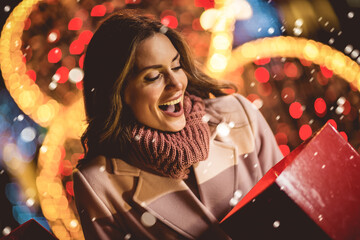 Beautiful brunette woman open present box on christmas market