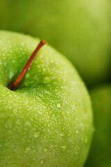 Juicy Green apple close-up with dew drops.