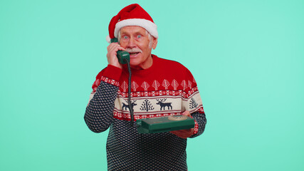 Hey You, call me back. Senior Christmas grandfather man talking on wired vintage telephone of 80s,...
