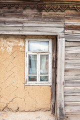 Window with wooden frames in an old wooden house in dilapidated condition