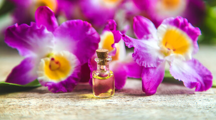 Obraz na płótnie Canvas Orchid essential oil in a small bottle. Selective focus.