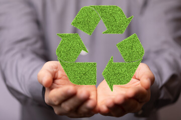 hand holding green recycle symbol