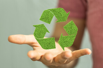 hand holding green recycle symbol