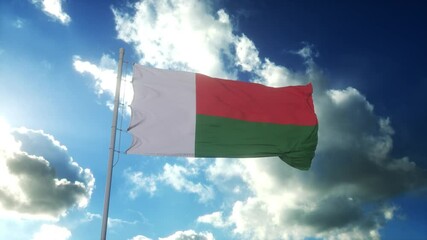 Flag of Madagascar waving at wind against beautiful blue sky