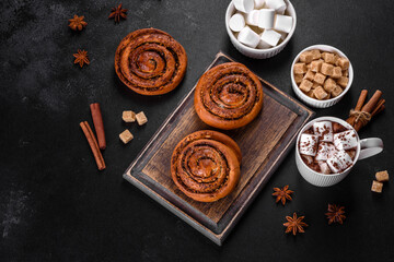 Freshly baked cinnamon roll with spices and cocoa filling on a black background